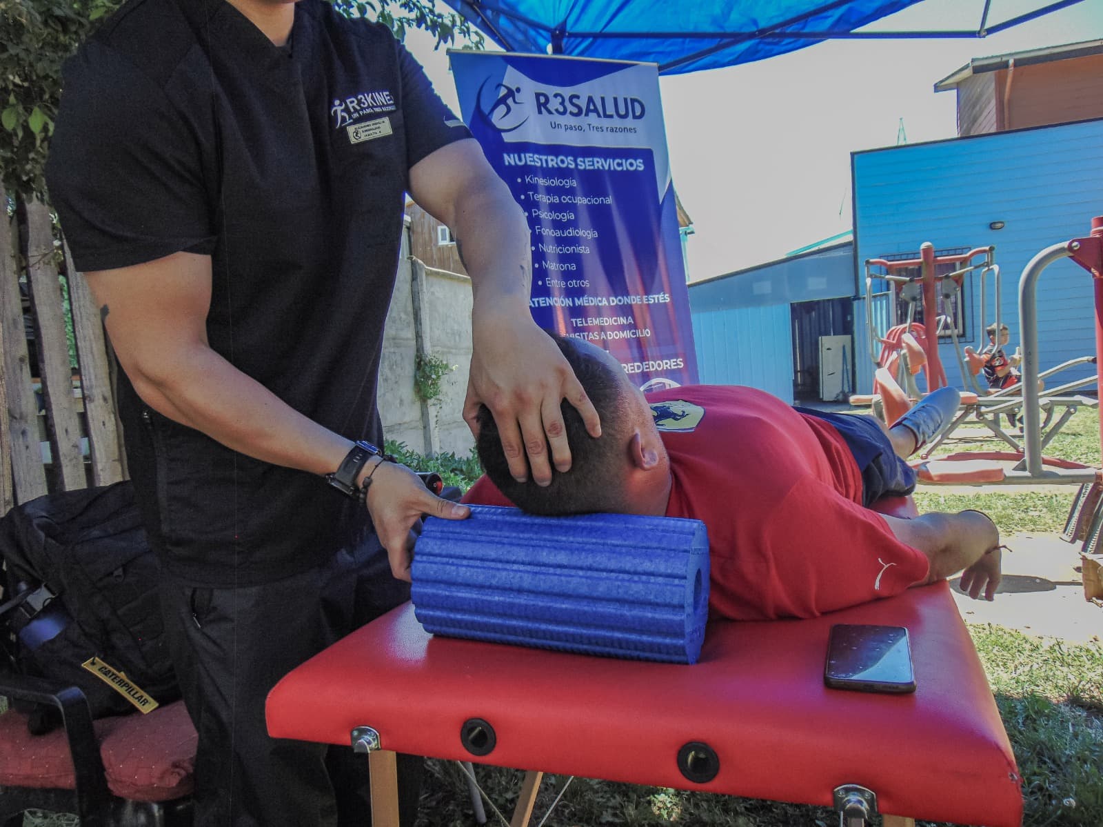 Kinesiólogo de R3SALUD aplicando una técnica con rodillo de espuma a un paciente recostado en camilla